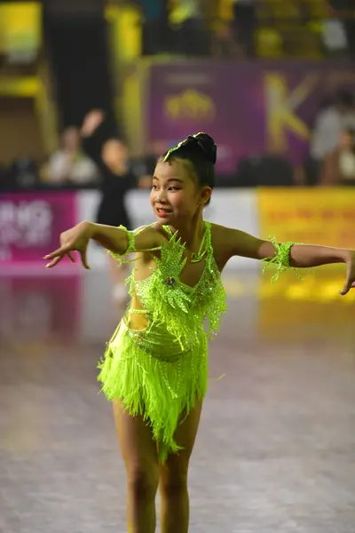 Dancesport competitor: Female dancer: lime green latin dress with fringe and sequins
