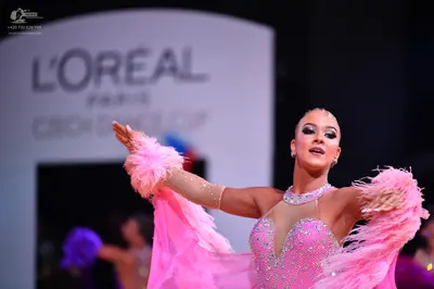 Dancesport competitor: Female dancer: pink Latin dress with sequin and crystal embellishments, featurin