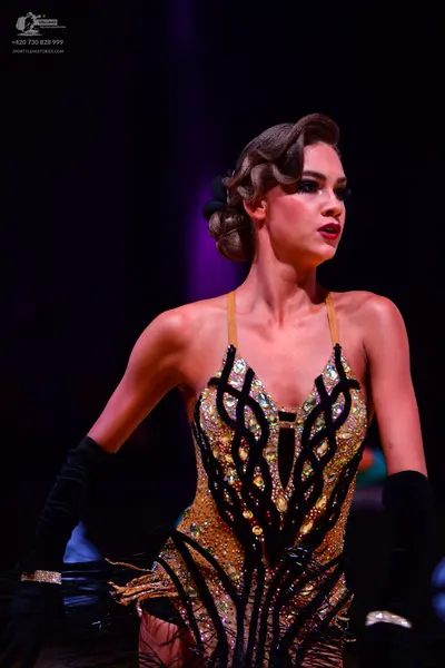 Dancesport competitor: Female dancer: gold and black latin dance dress with intricate crystal/sequin pa