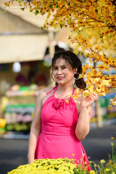 Dancesport competitor: Female dancer: bright pink halter-neck Latin dress with a fabric flower detail a