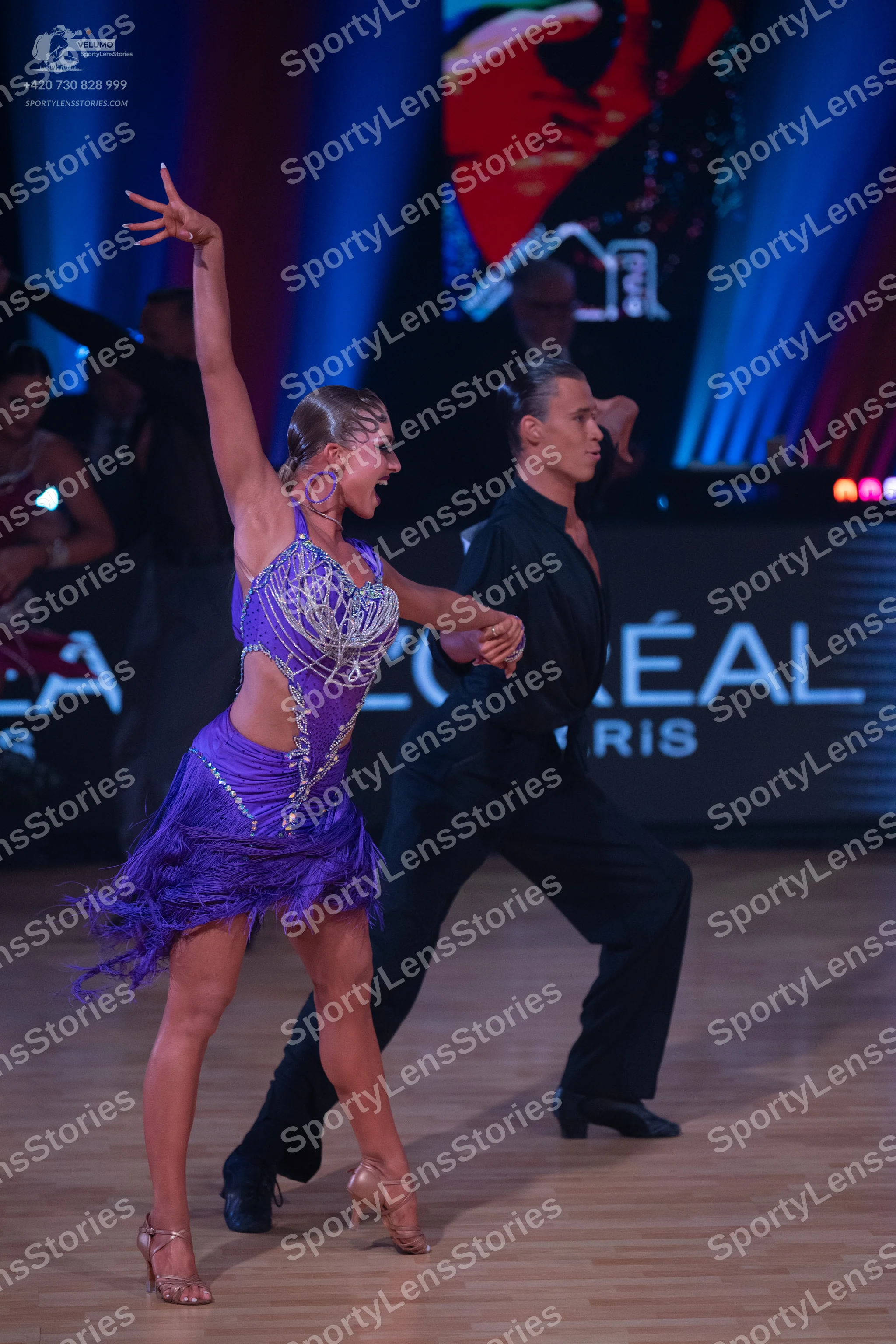 Dancesport competitor: Female dancer: purple Latin dress with silver sequin embellishments, side cut-ou