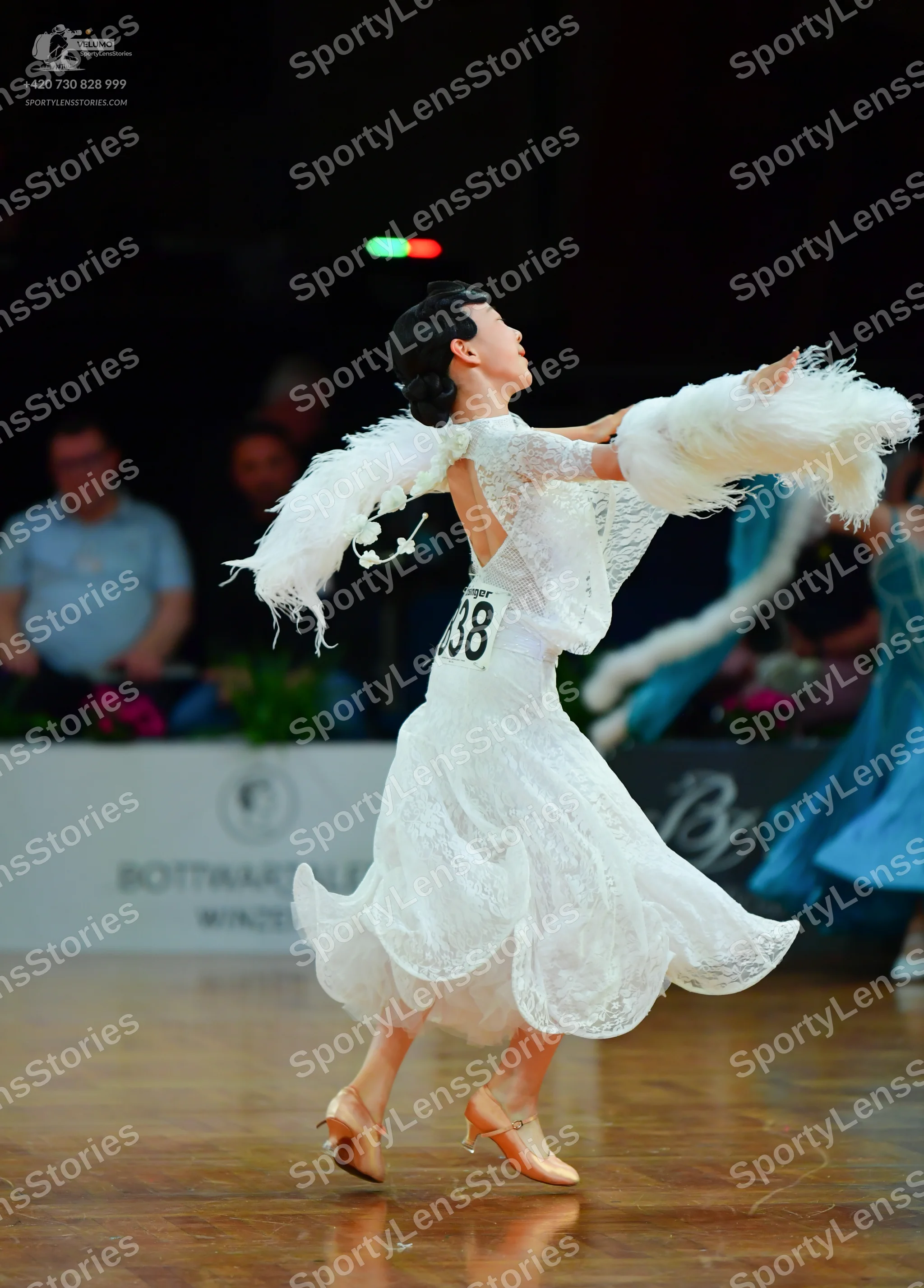 Dancesport competitor: Female dancer: white lace ballroom dress with long sleeves, a voluminous skirt, 