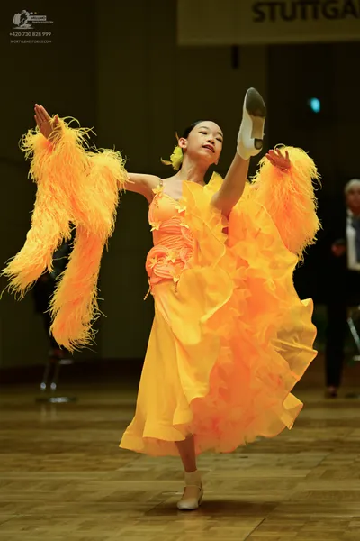 Dancesport competitor: Here’s a description of the dancers' costumes based on the image:

**Dancer 1 (F
