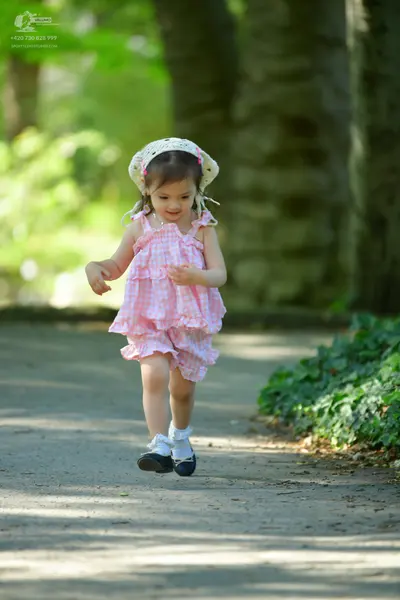 Dancesport competitor: Female dancer: pink and white gingham sleeveless ruffled dress, white socks, bla