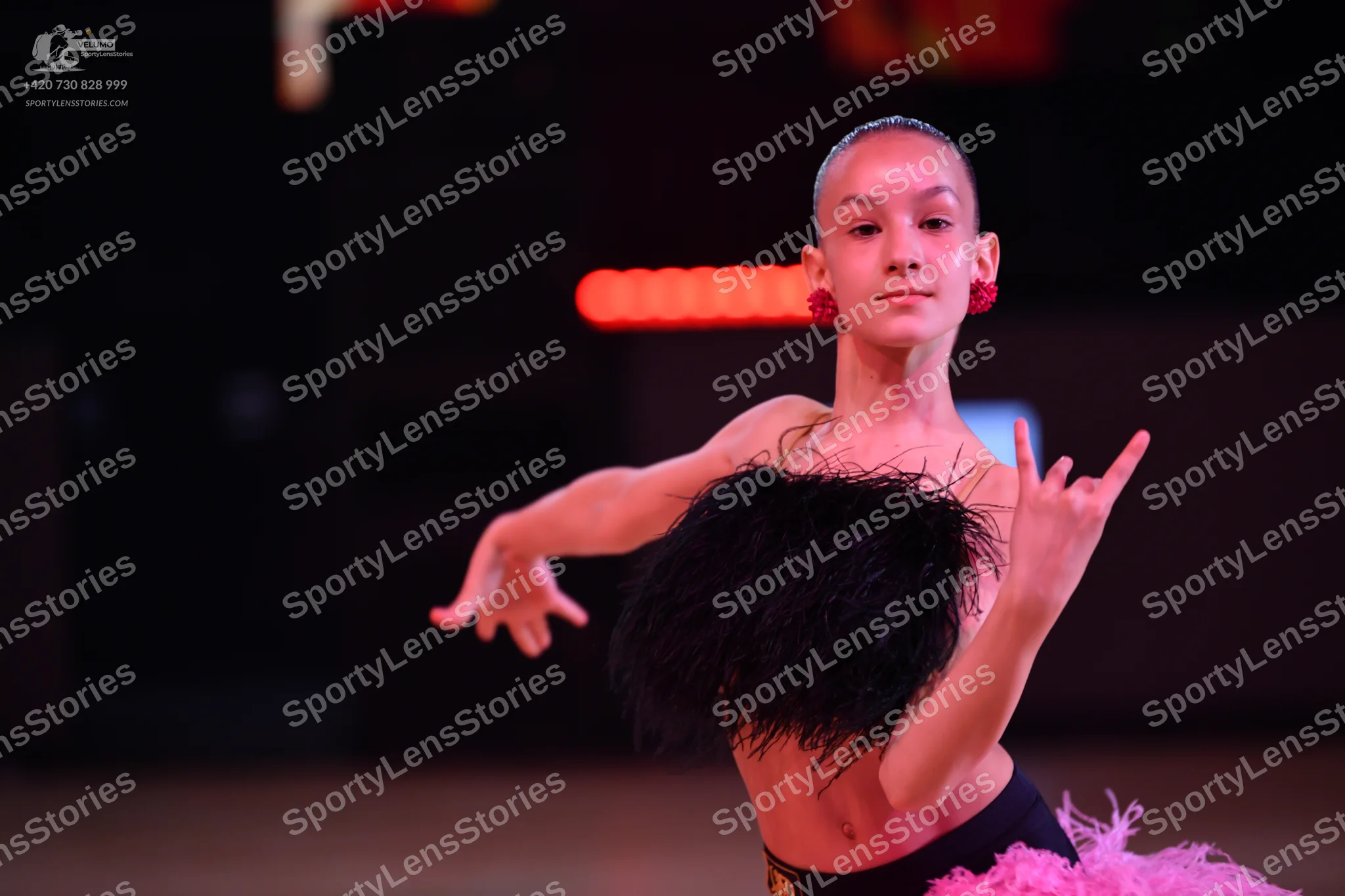 Dancesport competitor: Female dancer: black top with black feather-like texture, black waistband, and a
