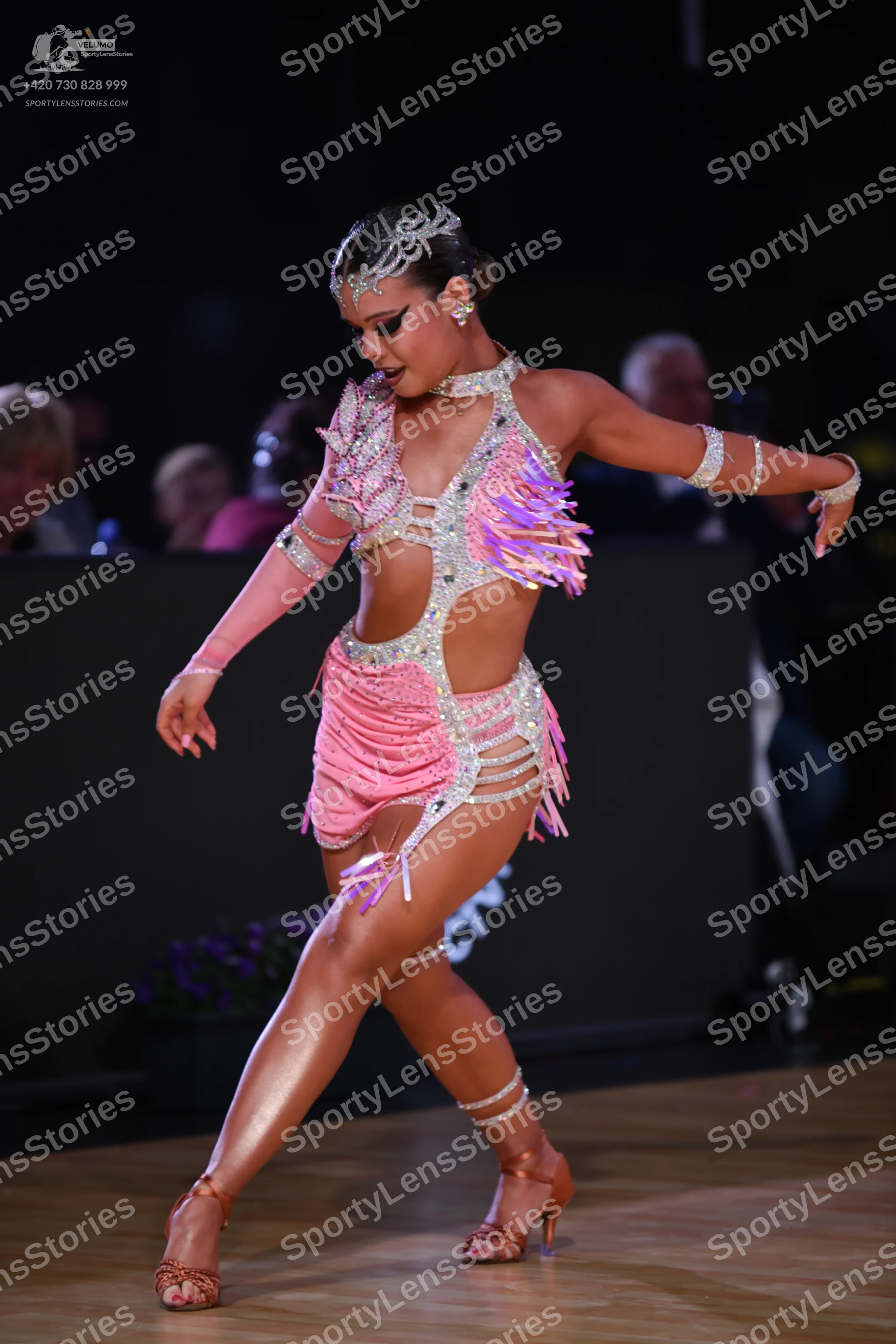 Dancesport competitor: Female dancer: pink sequined latin dress with fringe, silver/crystal headpiece,