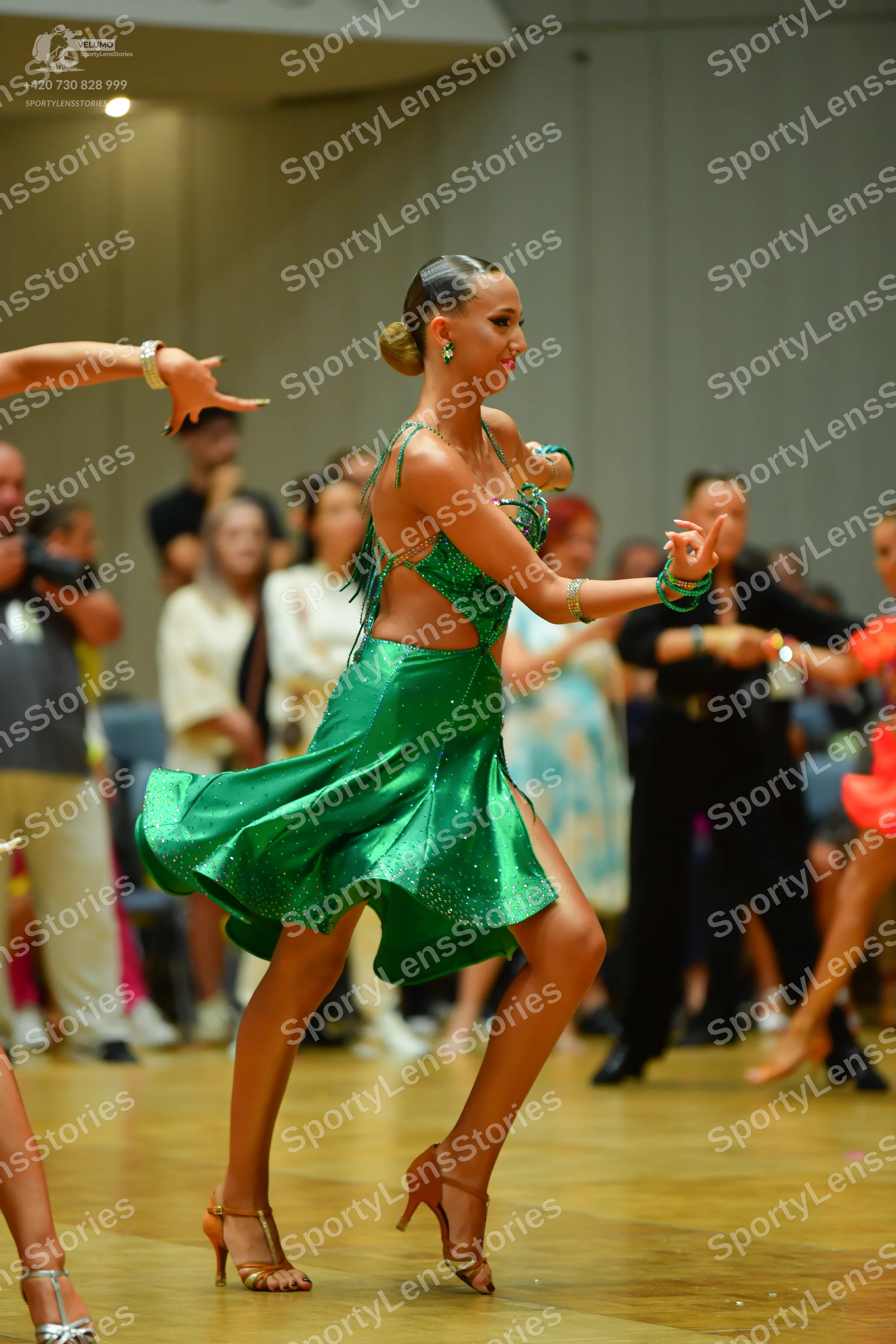 Dancesport competitor: Female dancer: emerald green latin dress with a shimmering fabric, fringe detail
