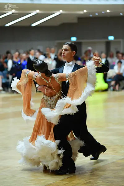 Dancesport competitor: Male dancer: black suit with white shirt and white bow tie