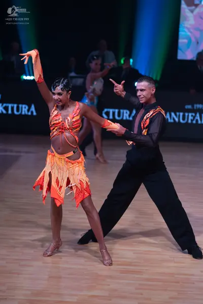 Dancesport competitor: Female dancer: orange and red Latin dance dress with a fringed skirt and matchin