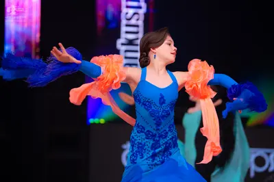 Dancesport competitor: Female dancer: blue latin dress with dark blue sequin patterns on the bodice, fe