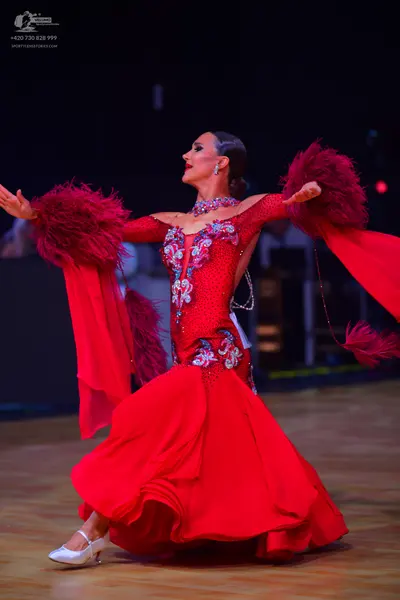 Dancesport competitor: Female dancer: red ballroom gown with a crystal-embellished bodice, long flowing