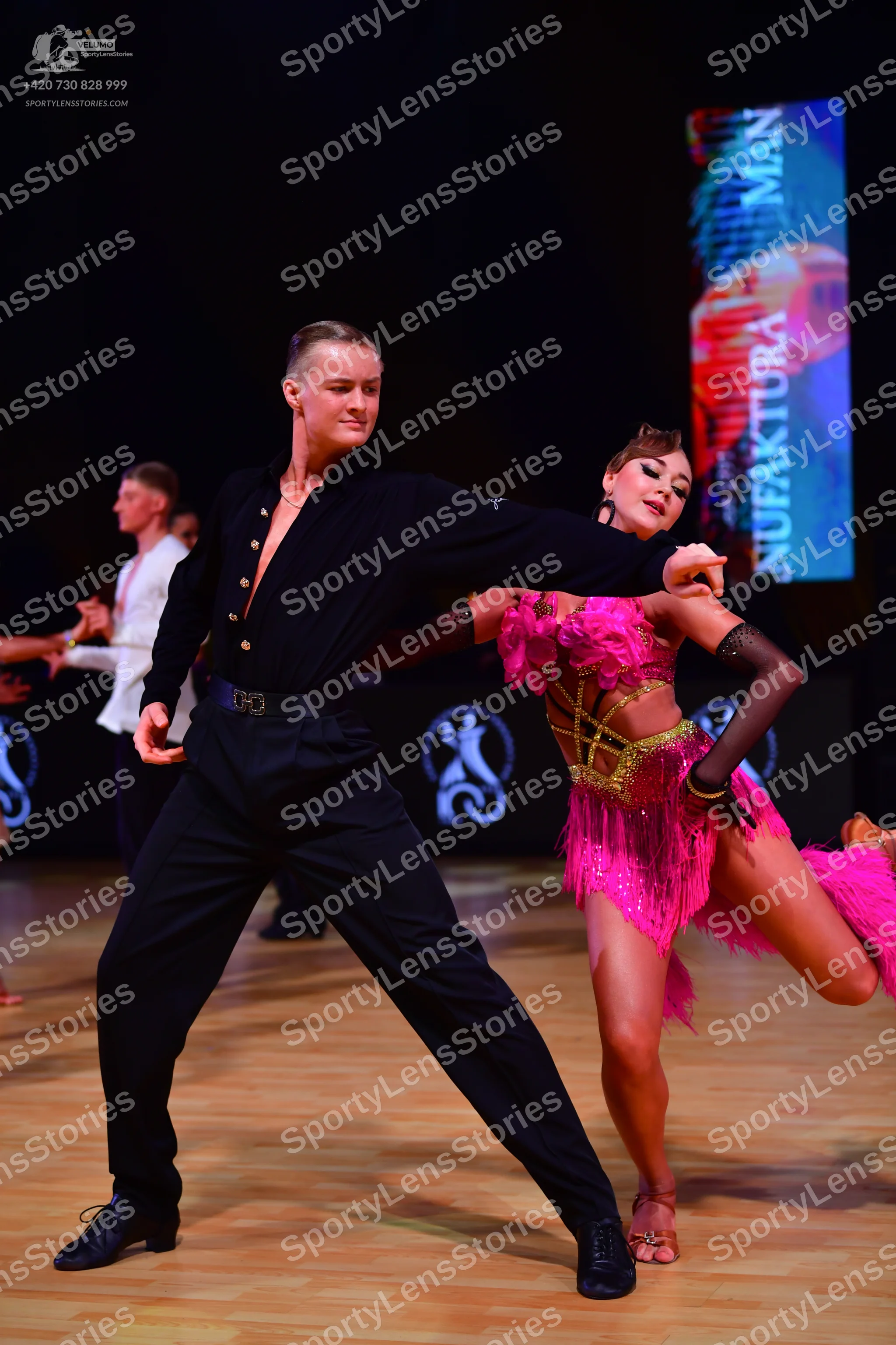 Dancesport competitor: Male dancer: black long-sleeved shirt, black trousers, black belt, and black dan