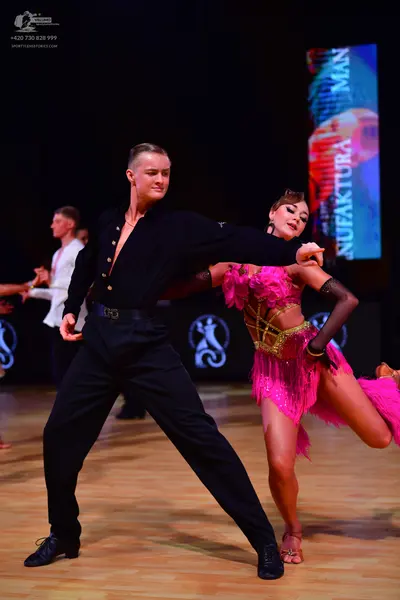 Dancesport competitor: Male dancer: black long-sleeved shirt, black trousers, black belt, and black dan
