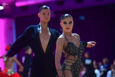 Dancesport competitor: Male dancer: black suit with a deep V-neck