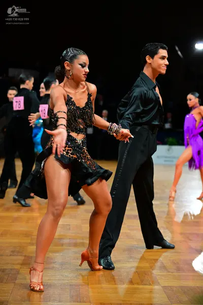 Dancesport competitor #78, #19: Female dancer (foreground): black sequined Latin dress with a ruffled hem and ma