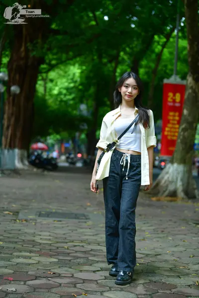 Dancesport competitor: Female dancer: white crop top, open white long-sleeved shirt, dark blue baggy tr