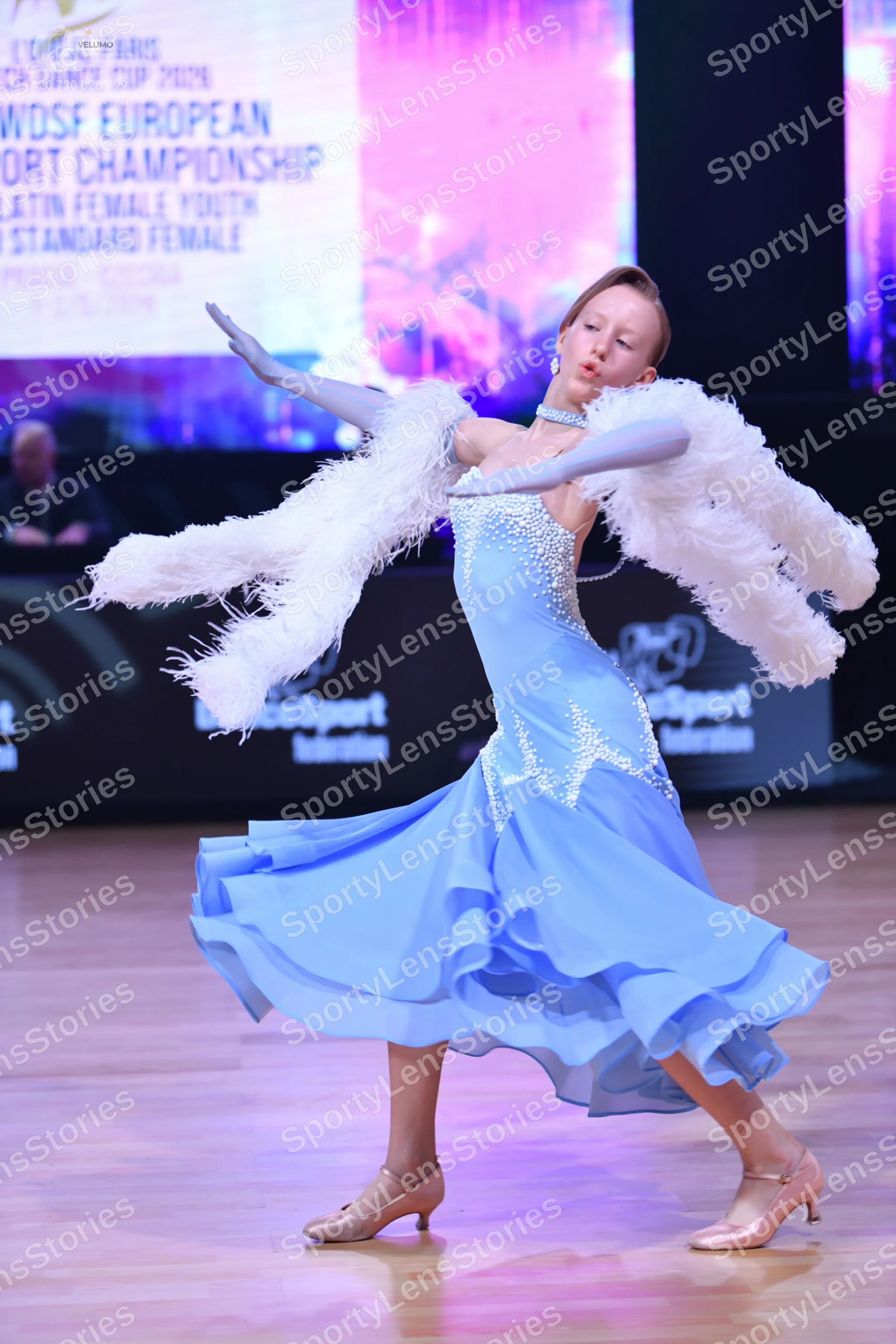 Dancesport competitor: Female dancer: light blue ballroom dress with silver embellishments and a flowin
