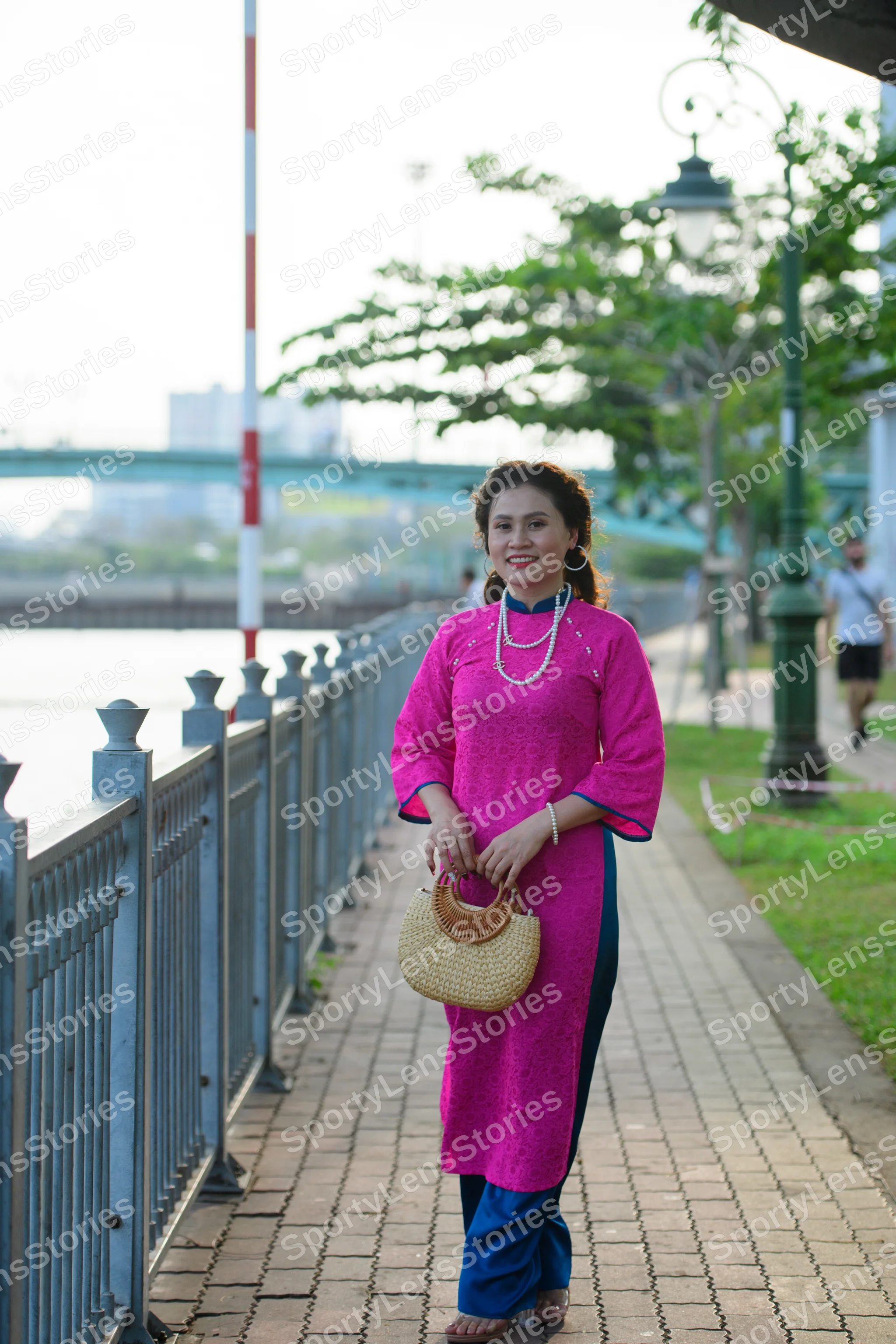 Dancesport competitor: Female dancer: bright pink embroidered long tunic (Áo dài) with blue trousers, p
