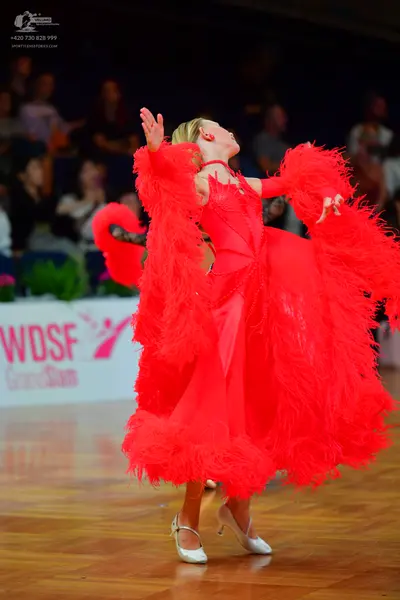 Dancesport competitor: Female dancer: bright red Latin dance dress with voluminous red feather trim on 