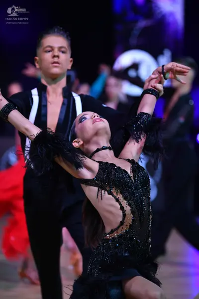 Dancesport competitor: Male dancer: black Latin dance shirt with white/silver satin panels and black tr