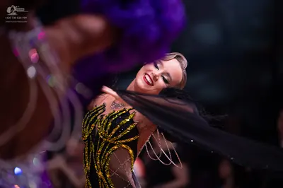 Dancesport competitor: Female dancer: black and gold Latin dance dress featuring intricate gold sequin 