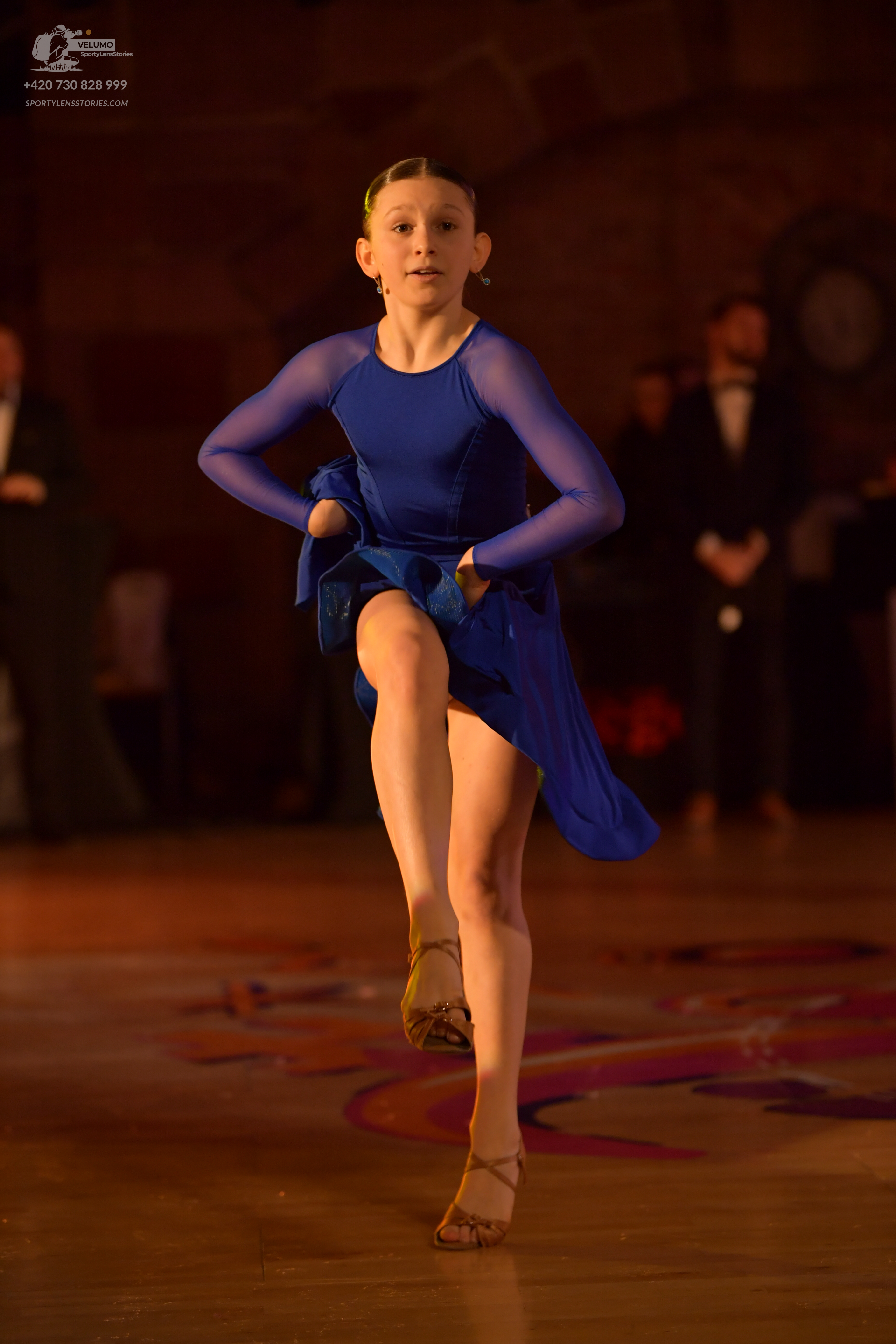Dancesport competitor: Female dancer: blue latin dress with long sheer sleeves