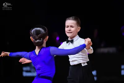 Dancesport competitor: Male dancer: white long-sleeved shirt, black bowtie, and black trousers