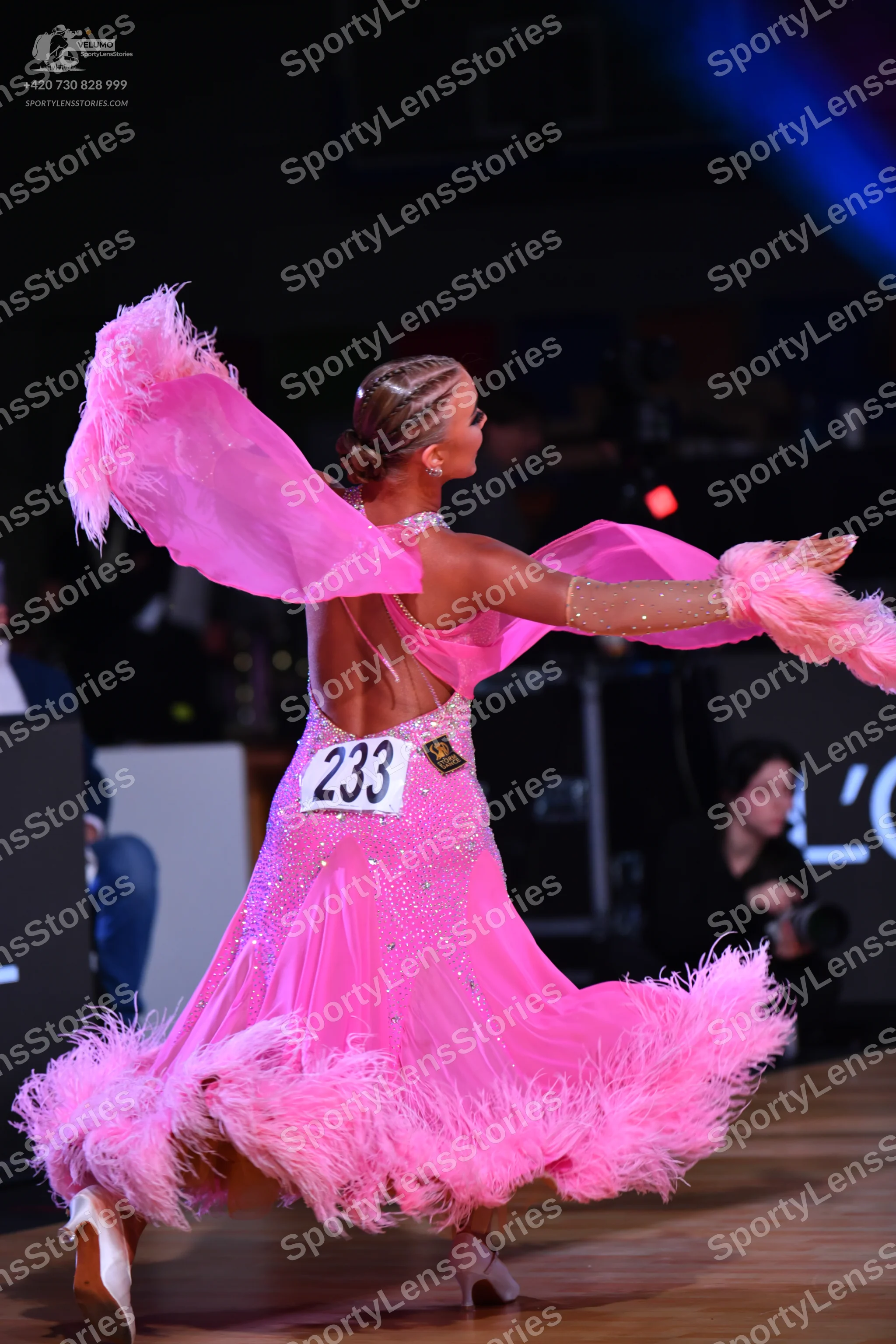 Dancesport competitor: Female dancer: bright pink latin dress with large pink feather trim on the skirt