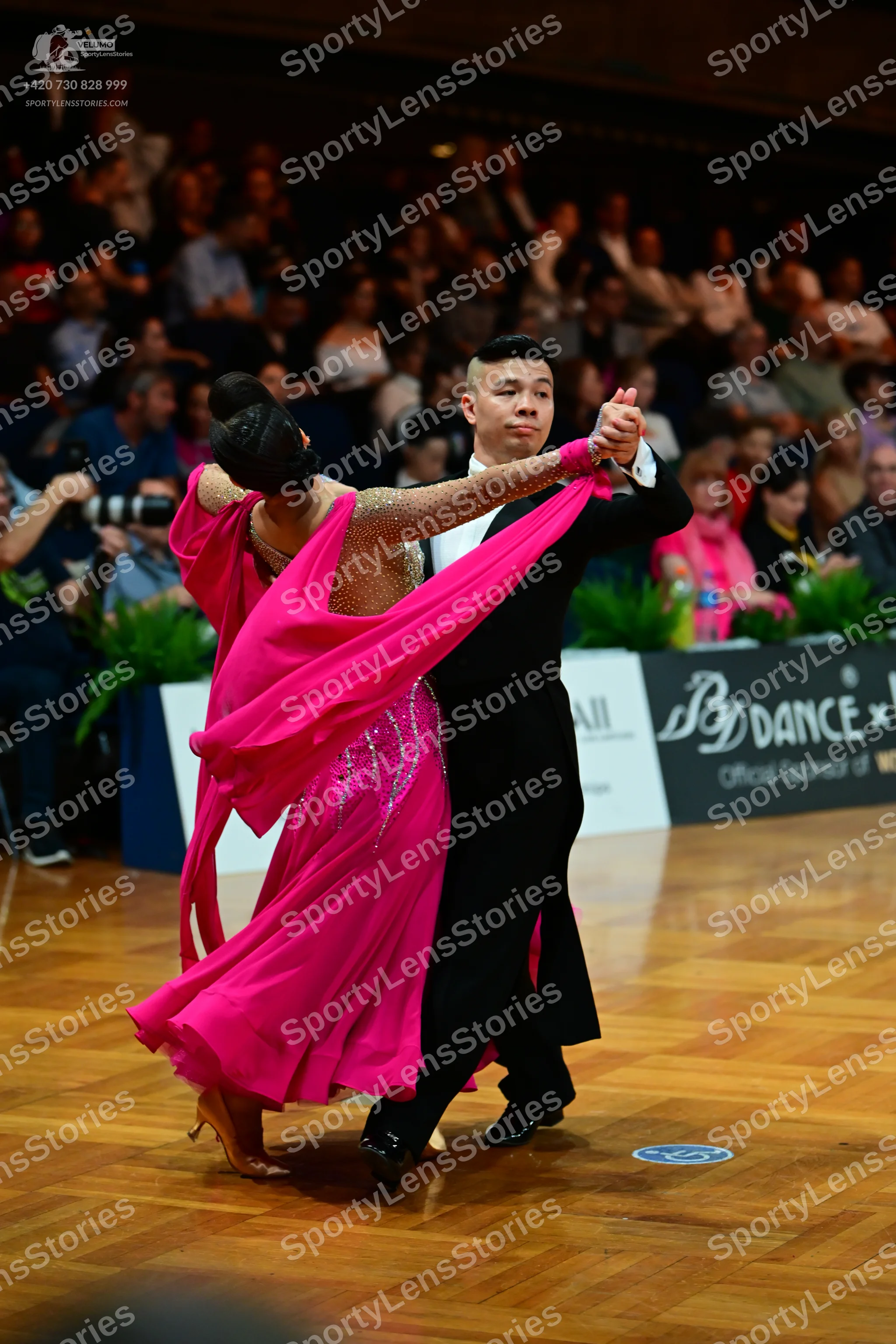 Dancesport competitor: Female dancer: bright pink ballroom dress with a full skirt and a nude-colored b