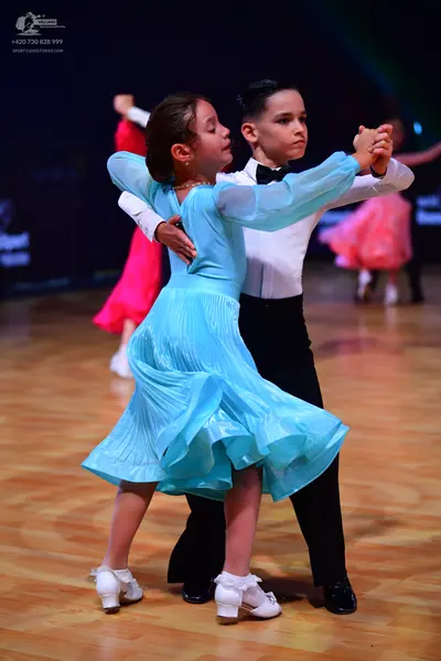 Dancesport competitor: Male dancer: white long-sleeved shirt, black trousers, and a black bowtie