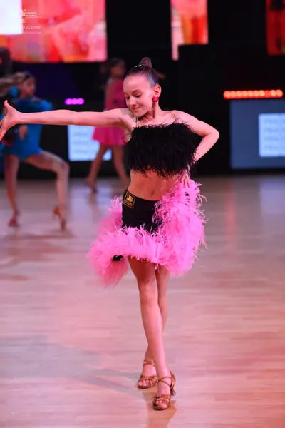 Dancesport competitor: Main dancer: black feathered top with a black high-waisted bottom and a large, v