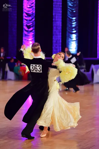 Dancesport competitor #363: Male dancer: black long-sleeved top with yellow feather accents and black trouse
