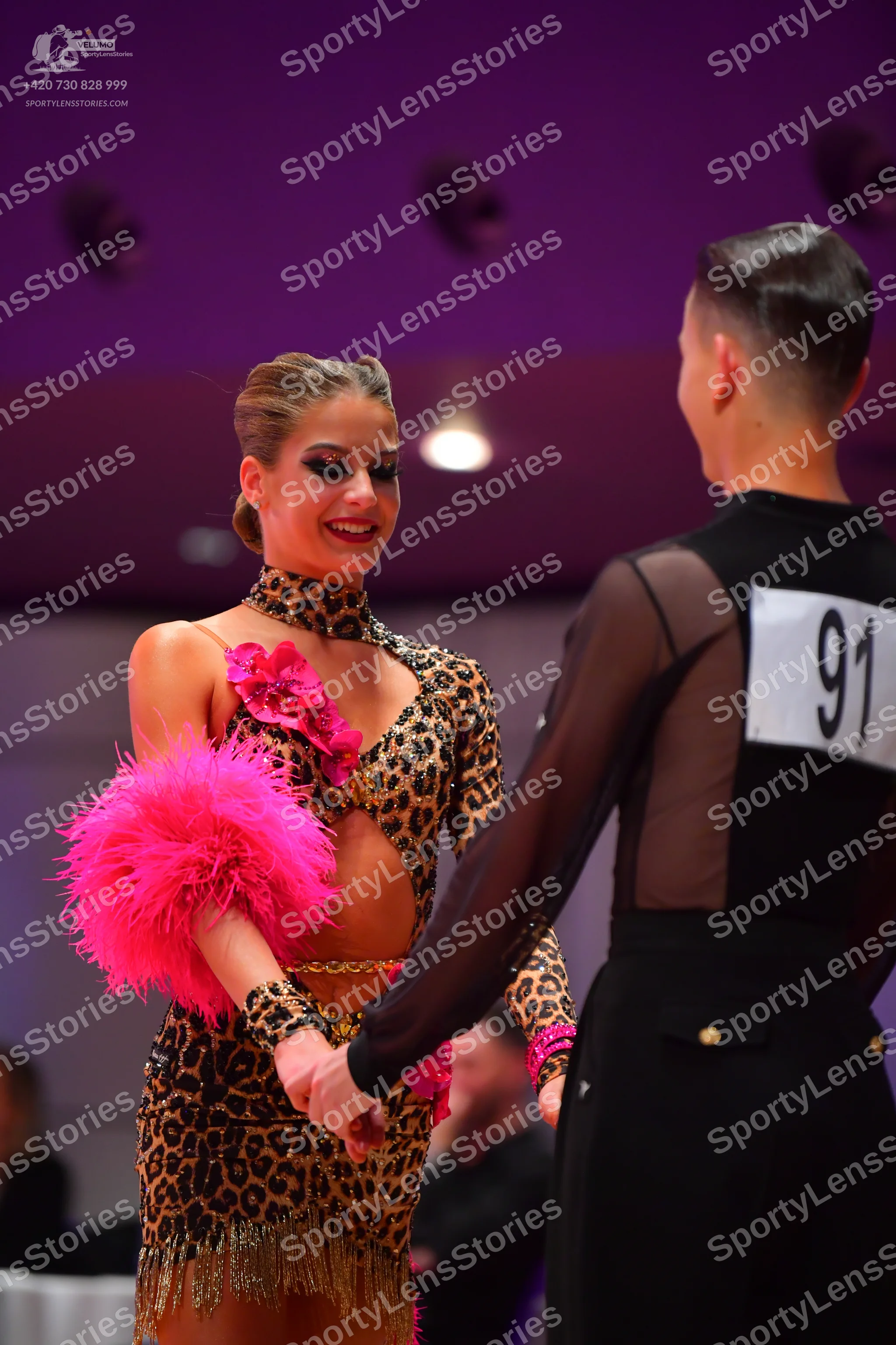 Dancesport competitor: Female dancer: leopard print Latin dress with long sleeves, high neck, cutouts,