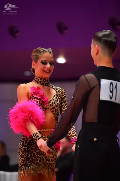 Dancesport competitor: Female dancer: leopard print Latin dress with long sleeves, high neck, cutouts, 