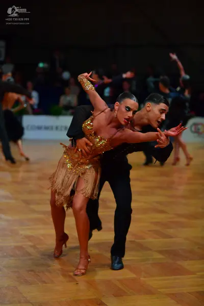 Dancesport competitor: Female dancer: gold/bronze Latin dress with sequins and fringe