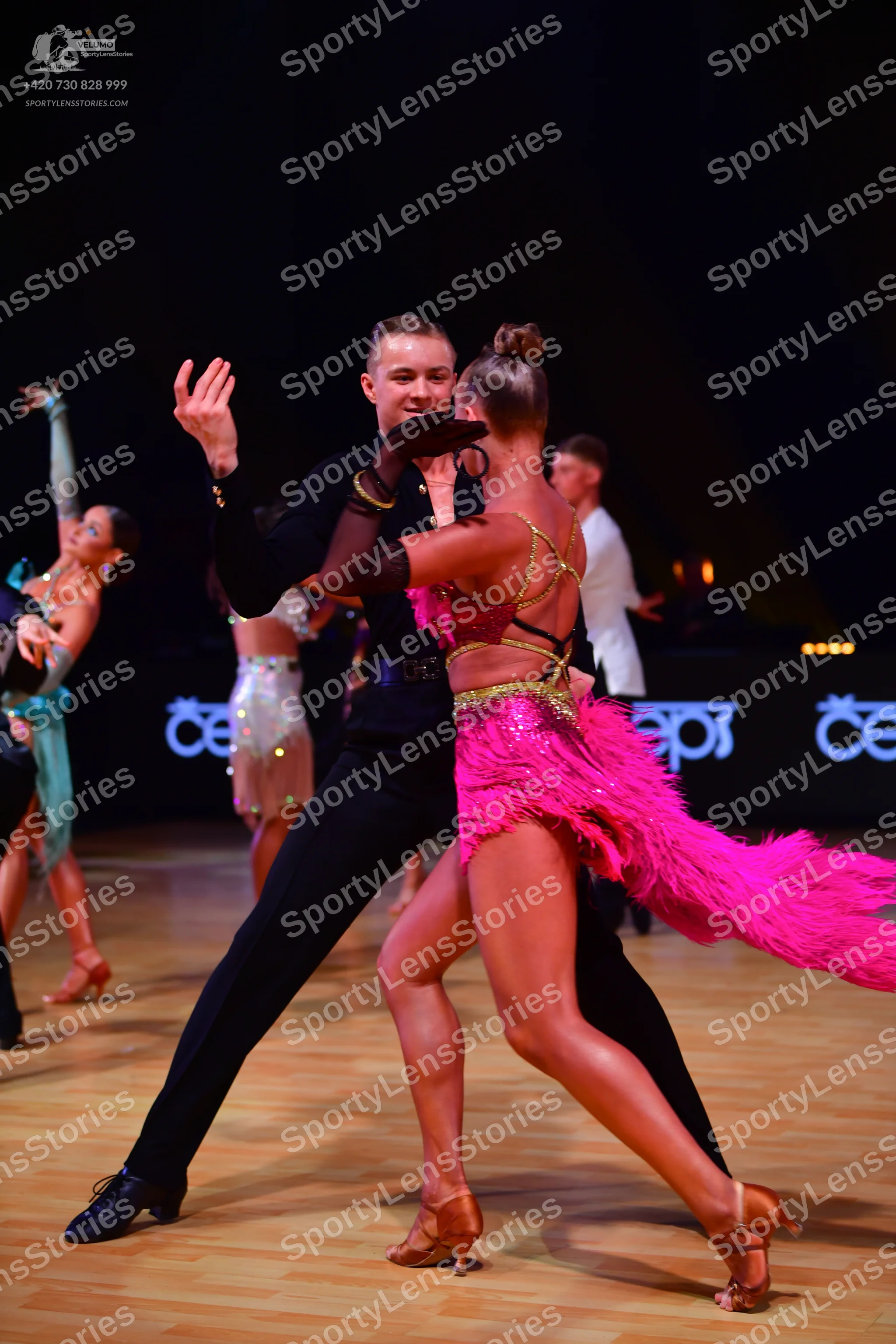 Dancesport competitor: Male dancer (foreground): black long-sleeved shirt and black trousers