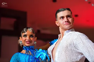 Dancesport competitor: Female dancer: blue sequined Latin dress with fringe and sparkly hair and ear ac