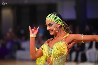 Dancesport competitor: Female dancer: lime green latin dress with sequins and fringe, matching headband
