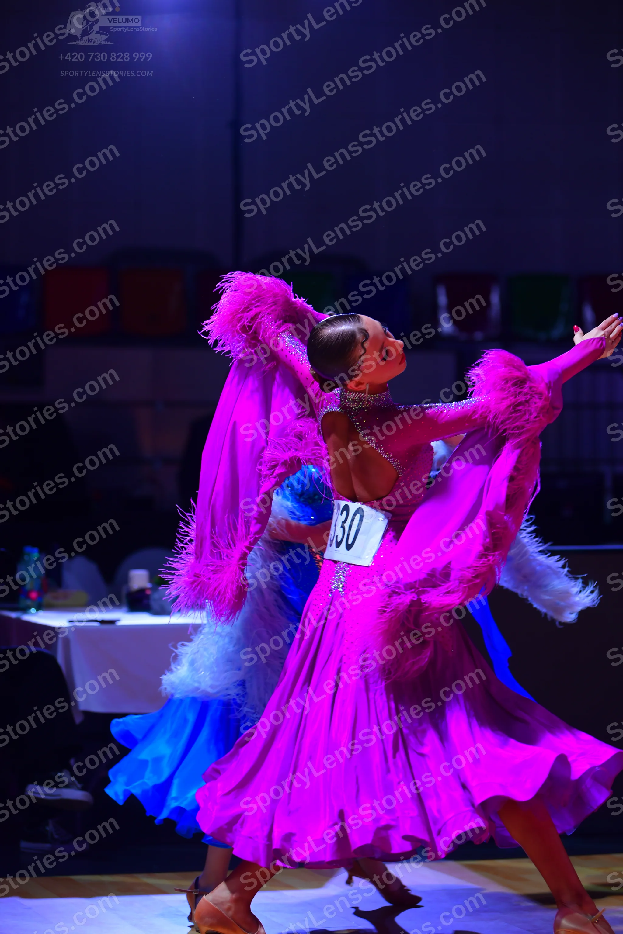 Dancesport competitor: Female dancer 1: magenta Latin dance dress with voluminous, textured sleeves