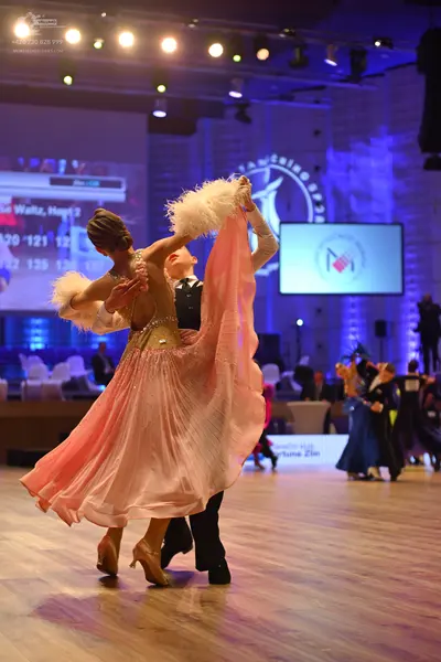 Dancesport competitor: Female dancer: light pink ballgown with a voluminous, flowing skirt, a nude-tone