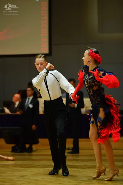 Dancesport competitor: Male dancer: white long-sleeved shirt with black trim and black trousers