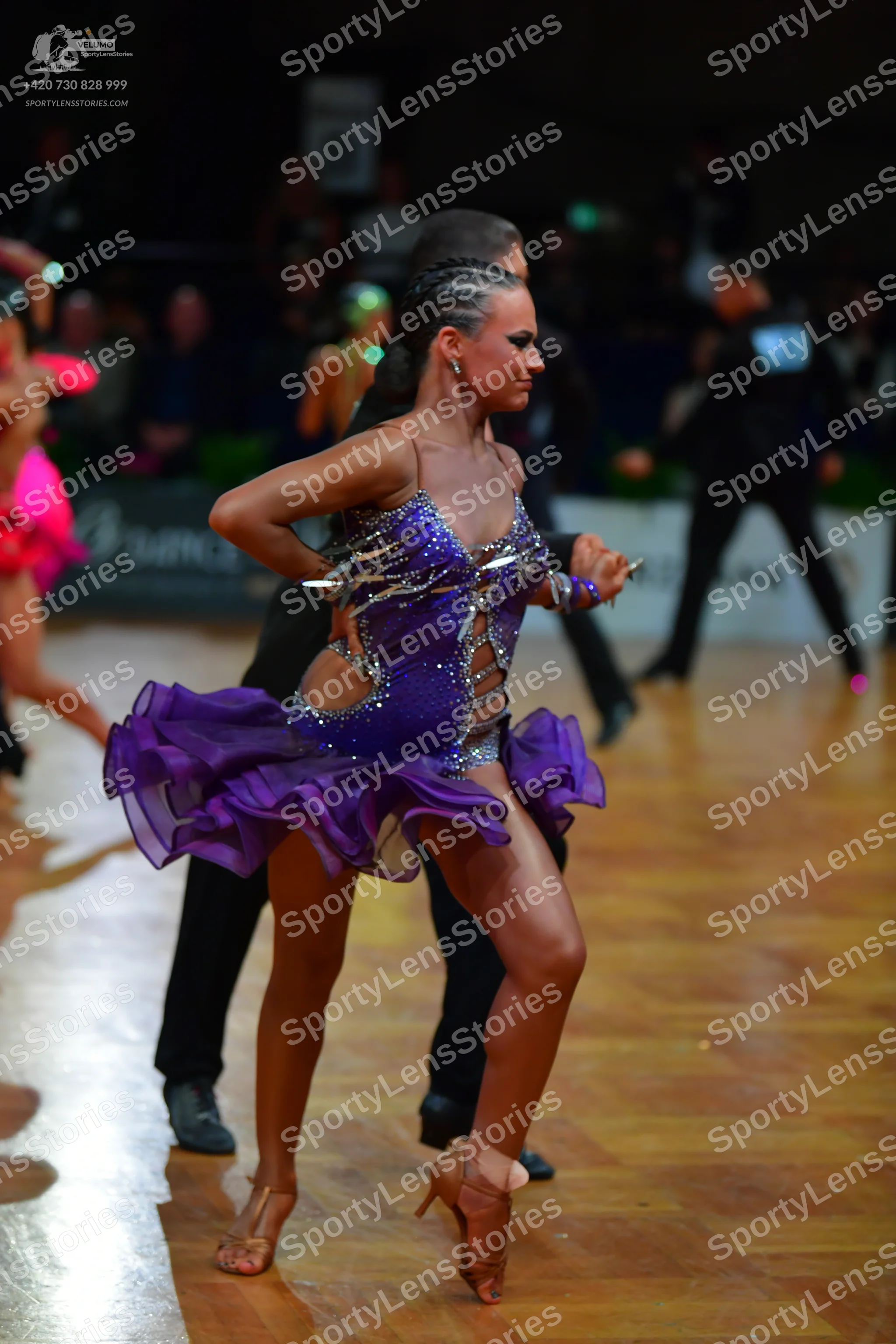 Dancesport competitor: Female dancer: purple latin dress with silver rhinestone embellishments and a ru
