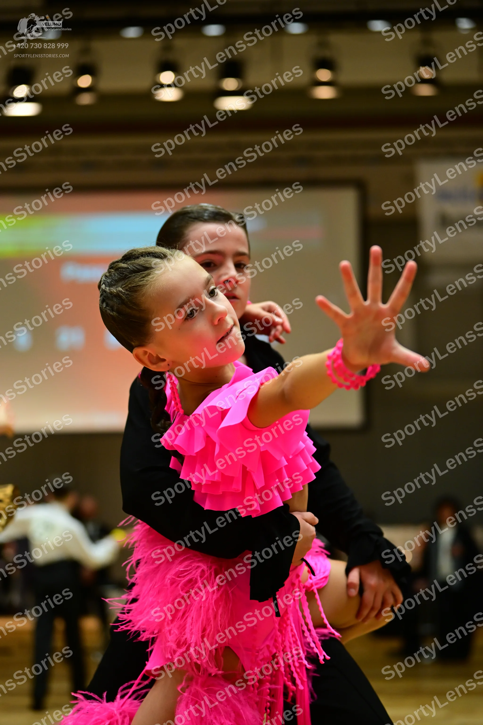 Dancesport competitor: Female dancer: bright pink latin dress with a ruffled bodice and long pink fring