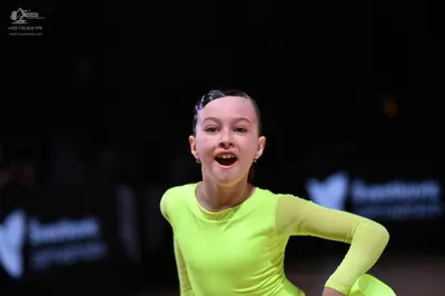 Dancesport competitor: Female dancer: lime green long-sleeved top made of smooth, stretchy fabric