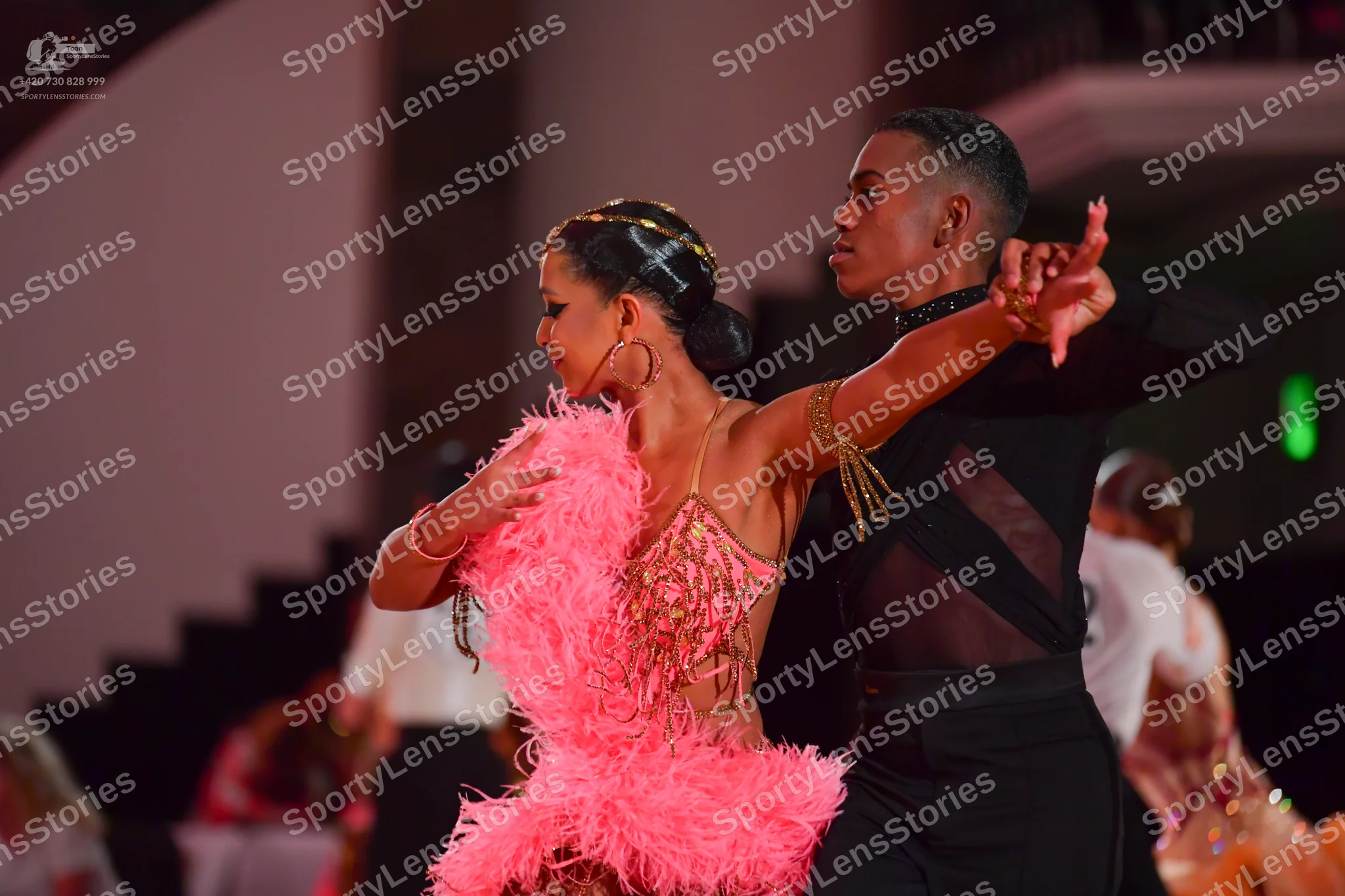 Dancesport competitor: Female dancer: pink Latin dance dress with a sequined and beaded bodice and a vo