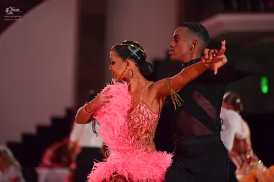 Dancesport competitor: Female dancer: pink Latin dance dress with a sequined and beaded bodice and a vo