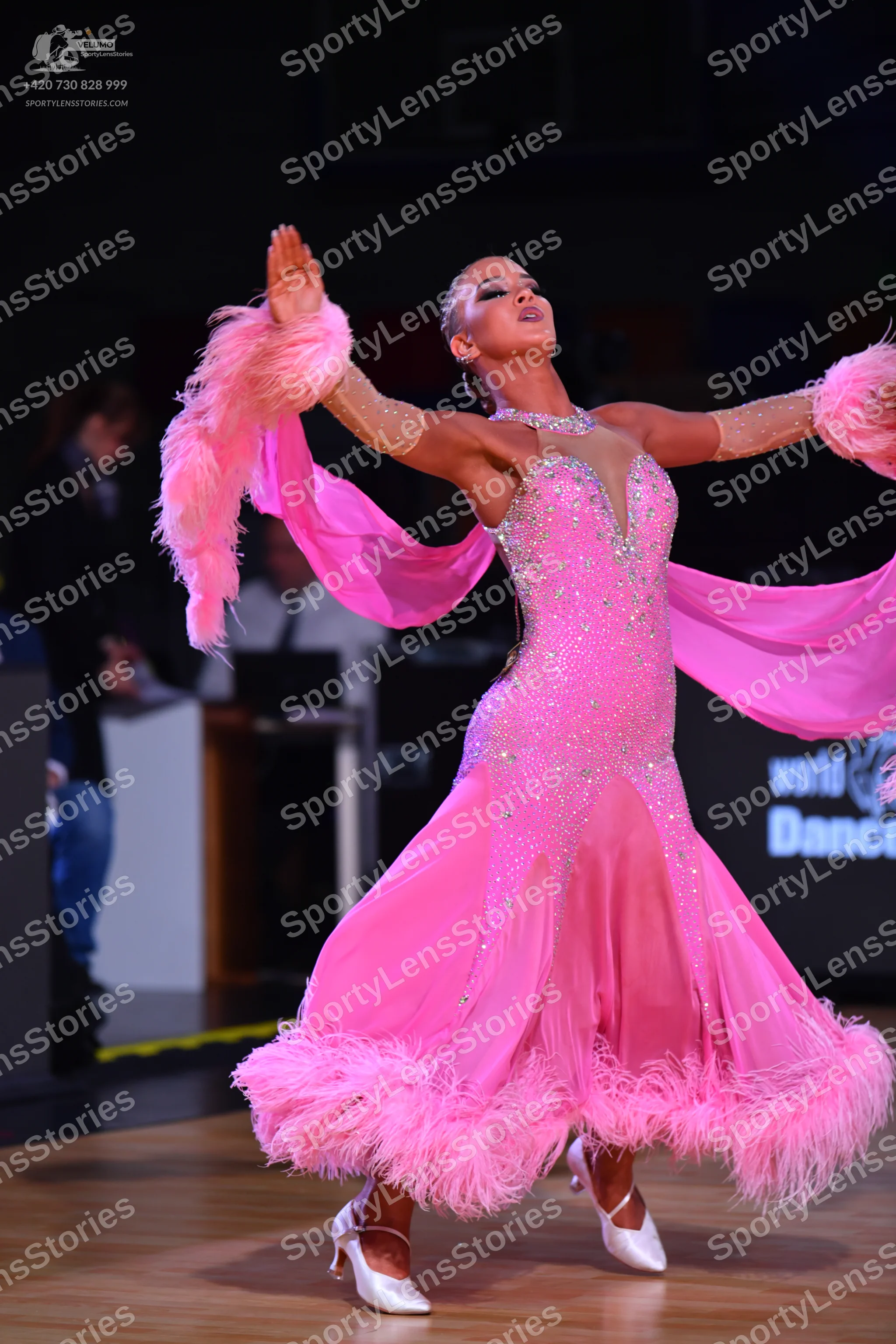 Dancesport competitor: Female dancer: bright pink ballroom dress with a sequined bodice, a flowing shee