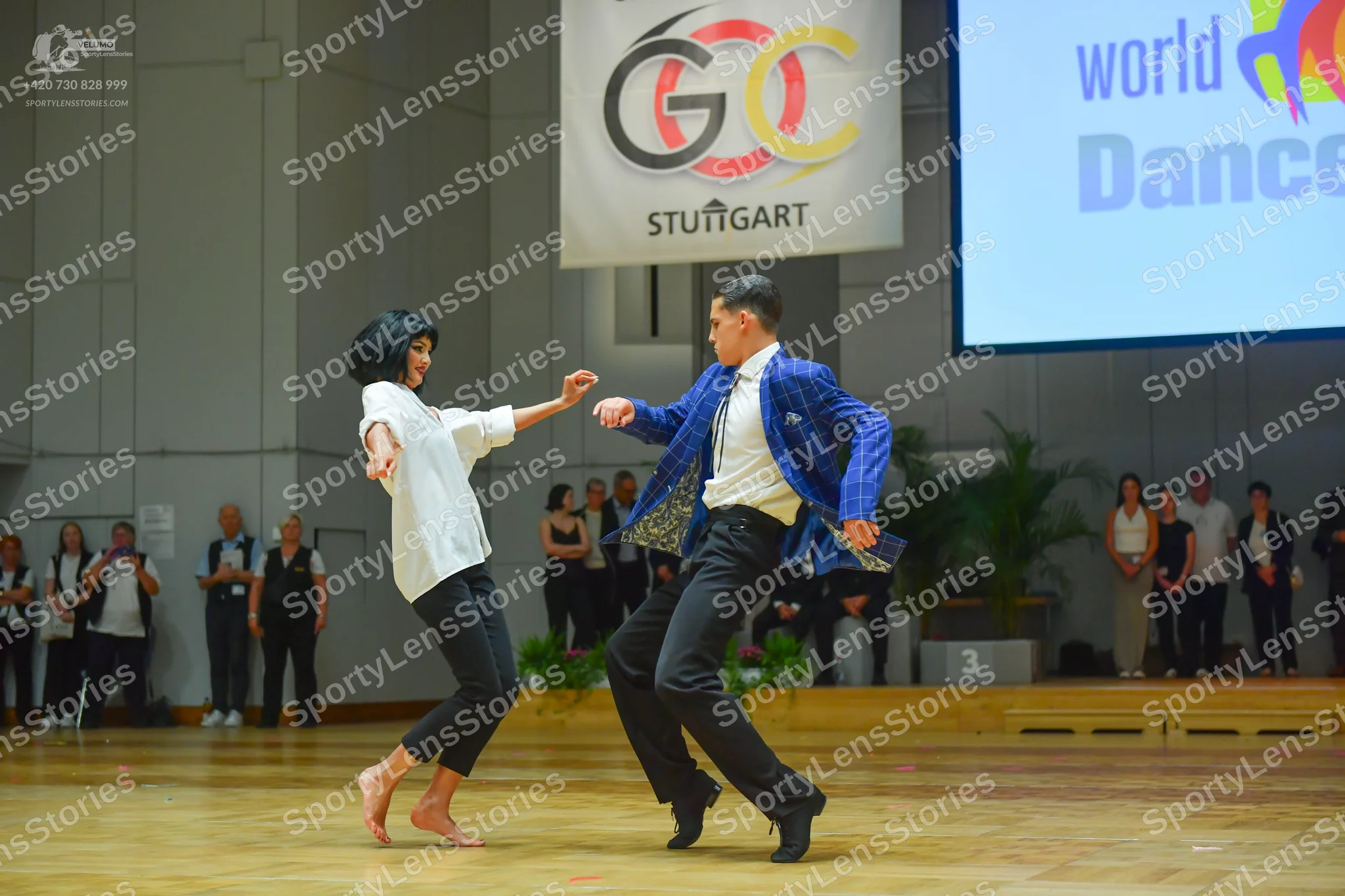 Dancesport competitor: Male dancer: blue patterned jacket, white shirt, black trousers, and black dance