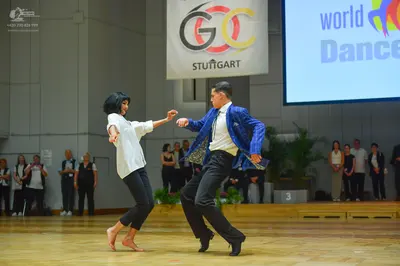 Dancesport competitor: Male dancer: blue patterned jacket, white shirt, black trousers, and black dance