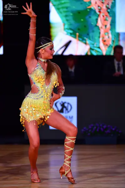 Dancesport competitor: Female dancer: yellow Latin dress with sequins and large paillettes, featuring c